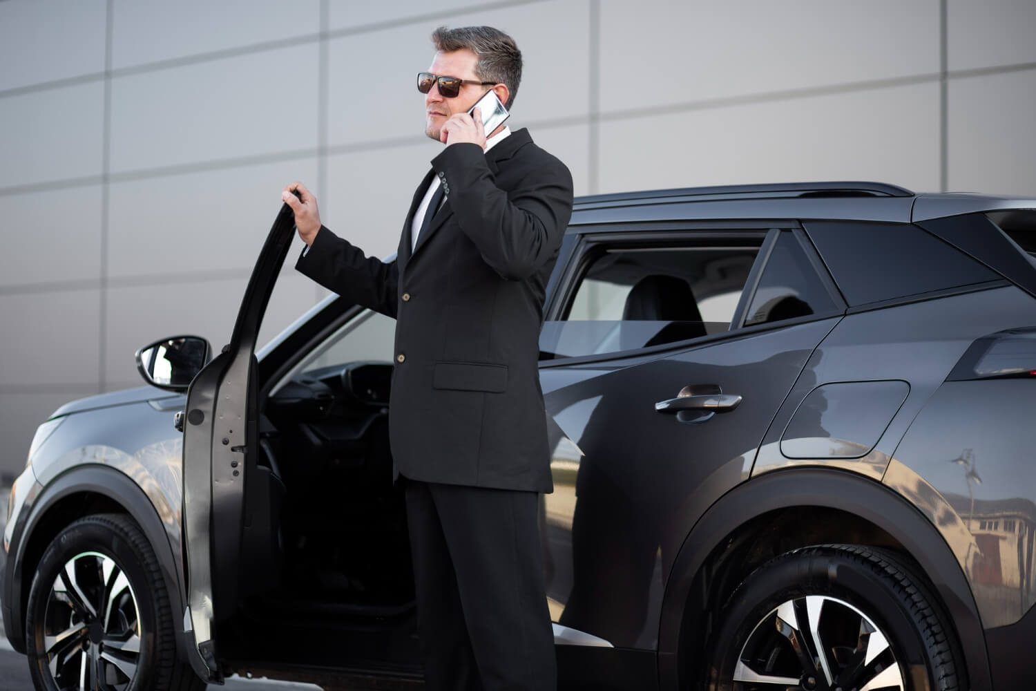 a businessman talking on the phone near his company car