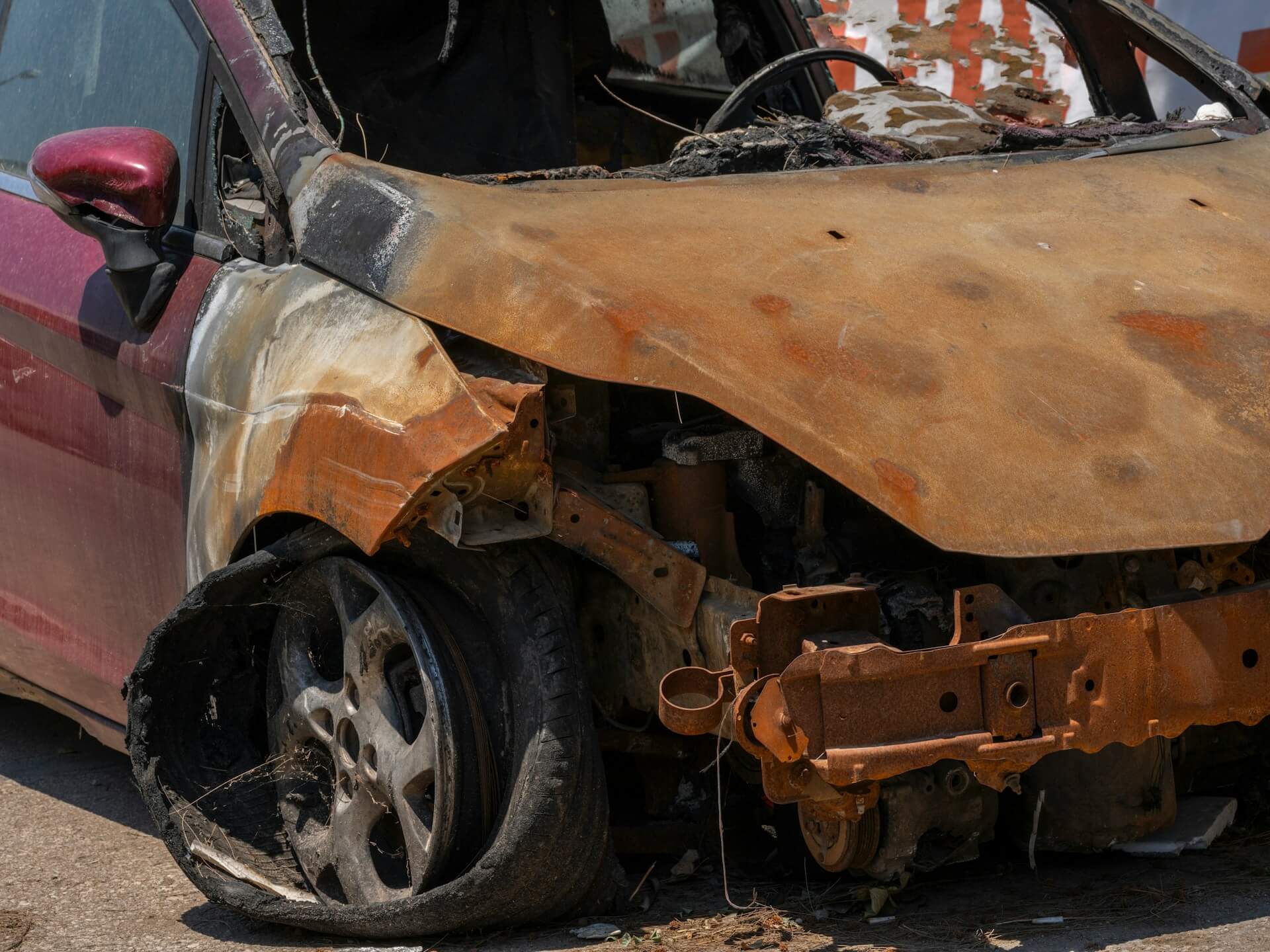 a burnt-out car with flat tires