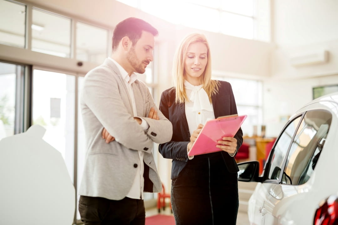 customer reviewing price or purchase paperwork with a sales representative