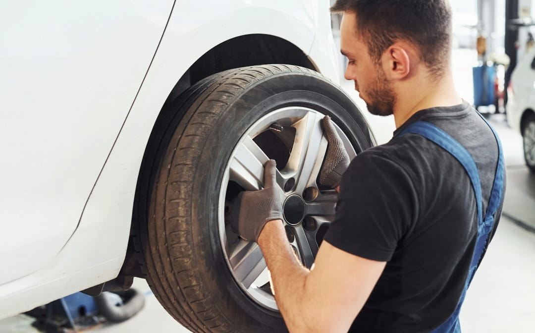 mechanic inspecting a car wheel on a lifted vehicle