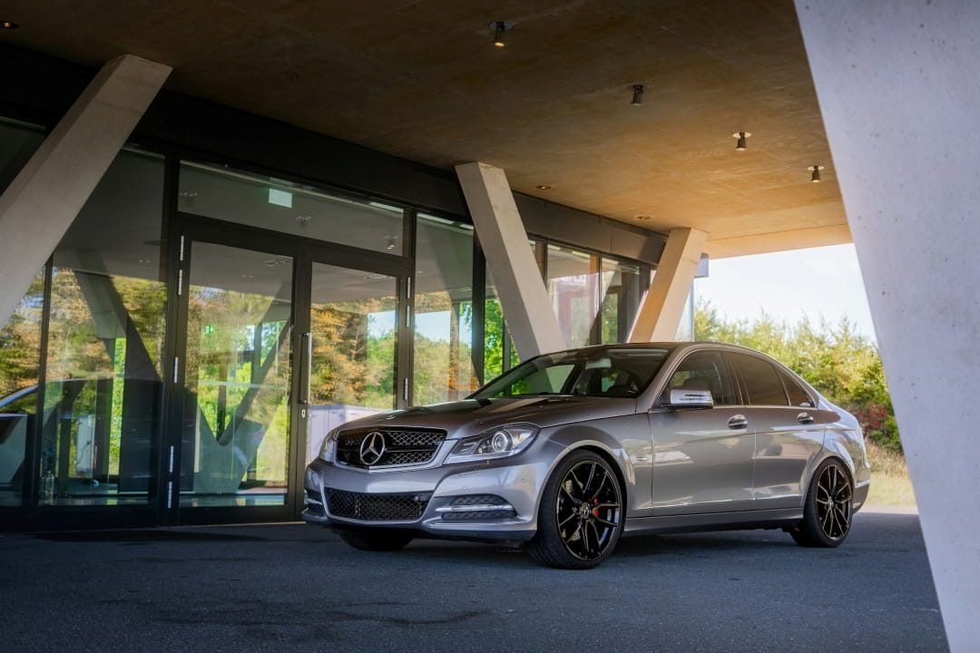 luxury sedan parked outside a modern car dealership building