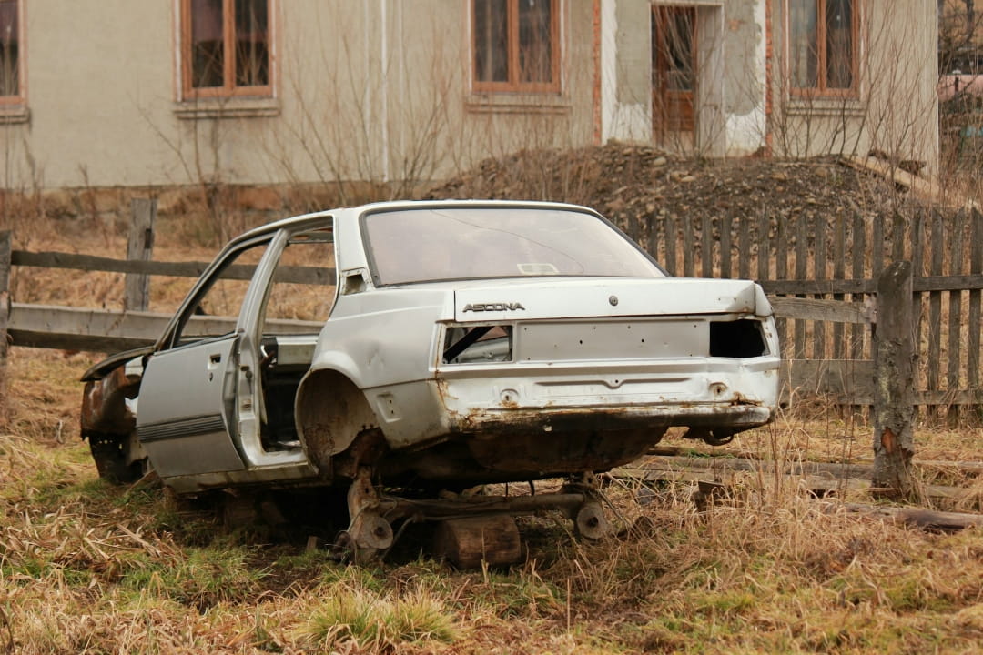 abandoned stripped car missing wheels and parts